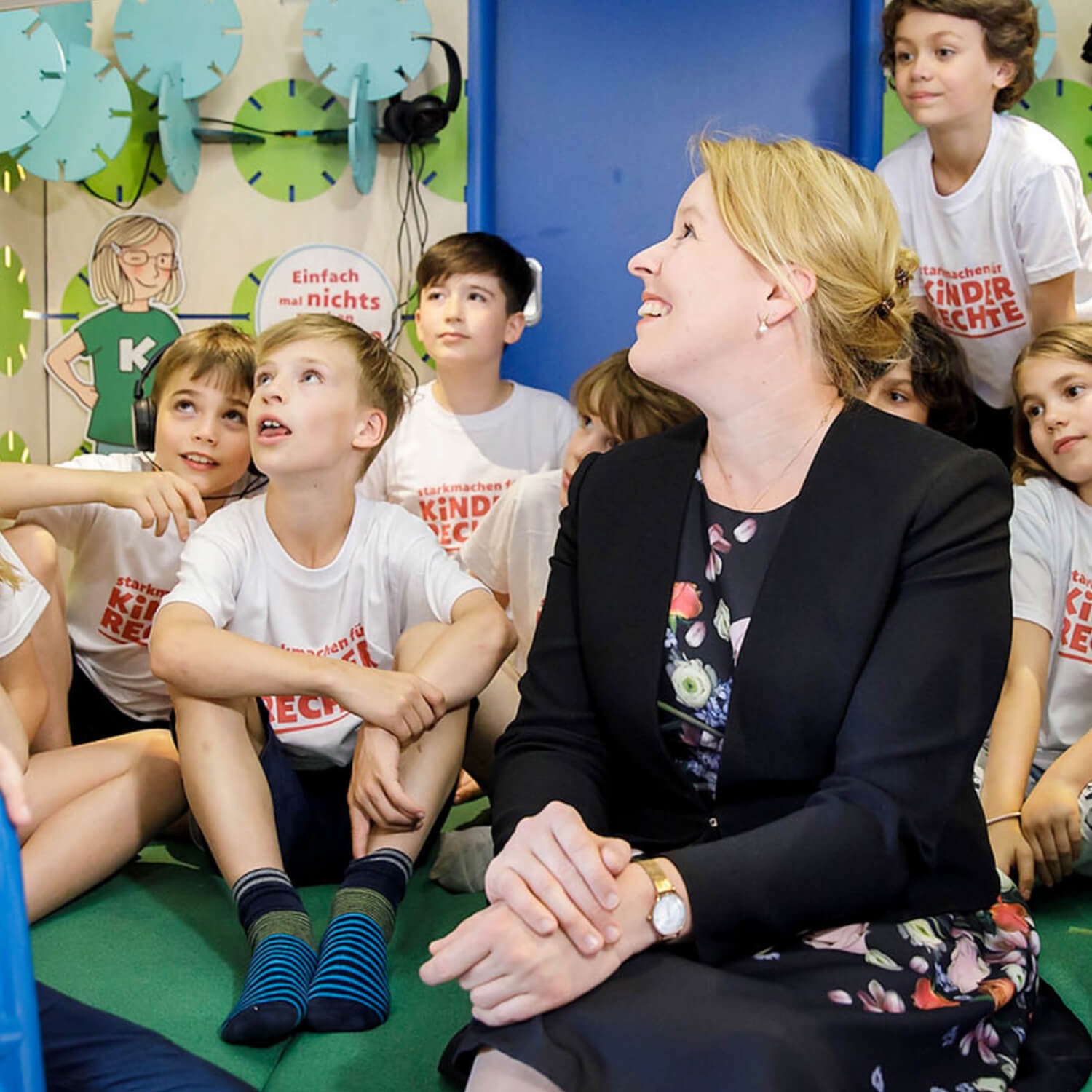 Bundesfamilienministerin Franziska Giffey sitzt neben mehreren Kindern.