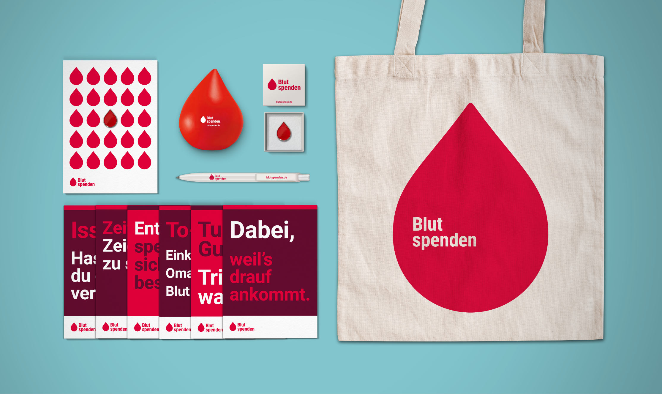 Mehrere Give-Aways wie Jutebeutel, Postkarten und einen Kugelschreiber im neuen Design der Blutspenden-Kampagne.